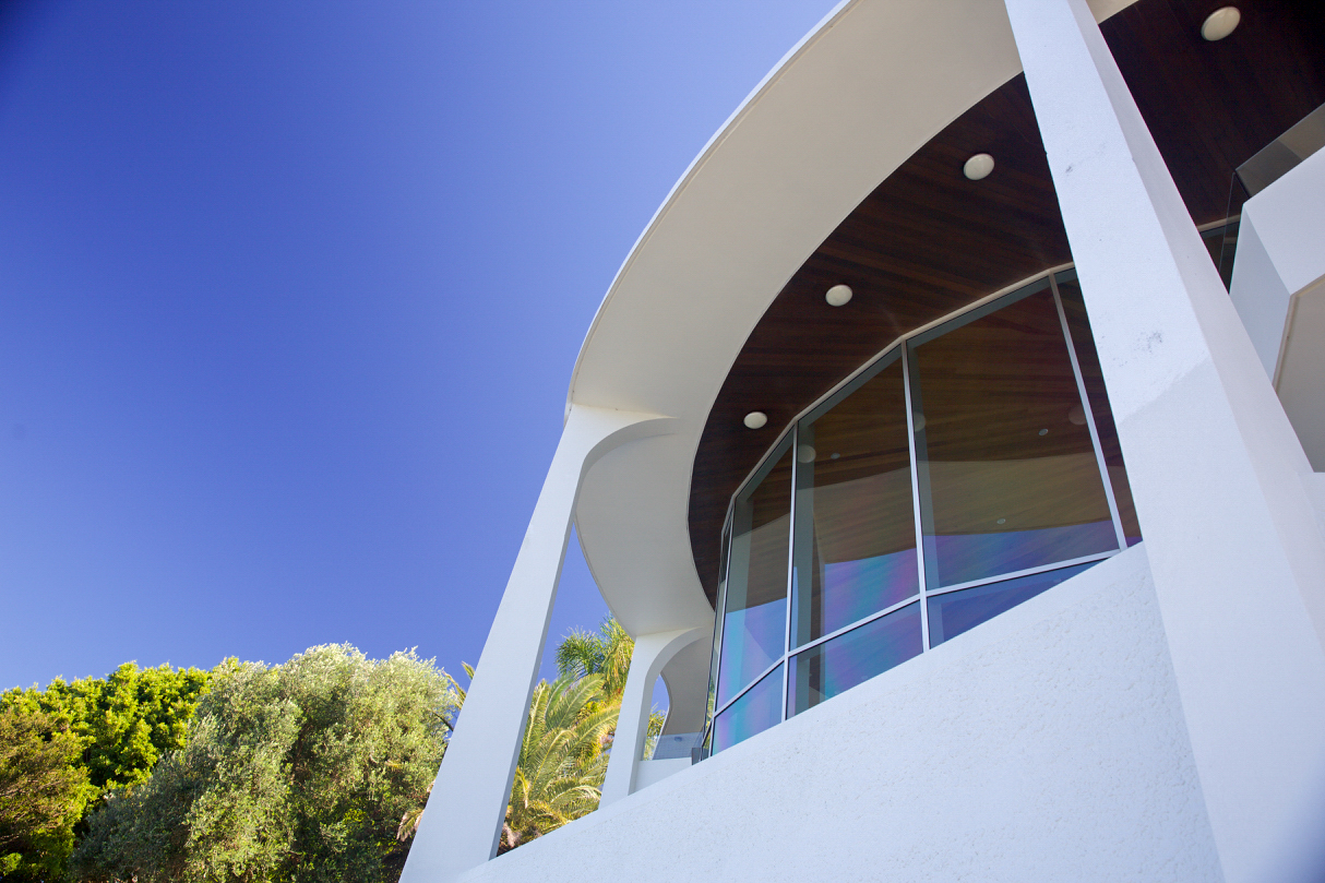 Curved rendered balcony detail against a blue sky